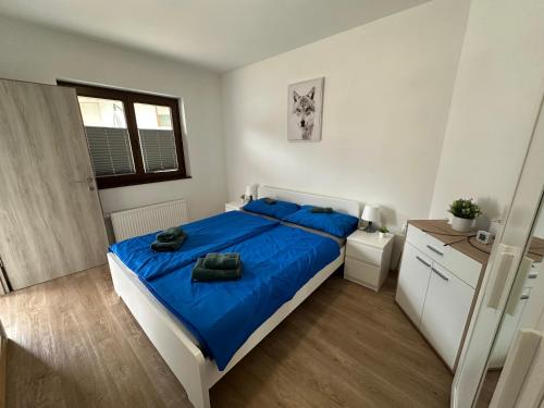 a bedroom with a large bed with blue sheets at APARTMA ALMA in Bovec