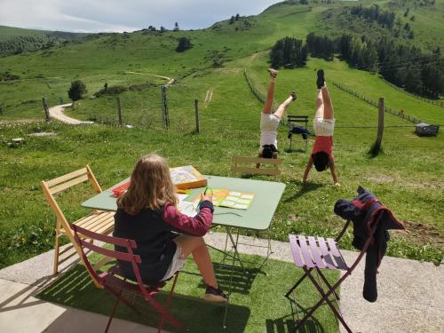 a group of people sitting at a table in the grass at Gîte avec vue exceptionnelle sur les montagnes in Camurac