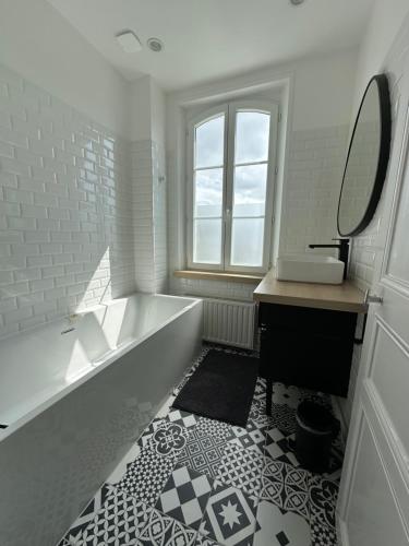 une salle de bain avec une baignoire, un lavabo et un miroir dans l'établissement Belle maison berckoise rénovée - LM la plage, à Berck-sur-Mer
