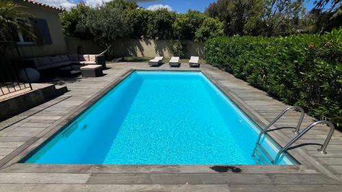 une piscine avec de l'eau bleue dans une cour dans l'établissement Villa Morticcione, à Zonza