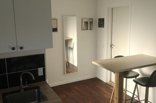 a kitchen with a sink and a counter and a table at HK Homes Apartments in Aarhus