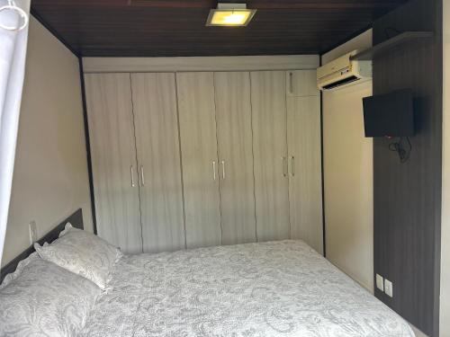 a bedroom with a bed and some wooden cabinets at Chalé Blumenau in Blumenau