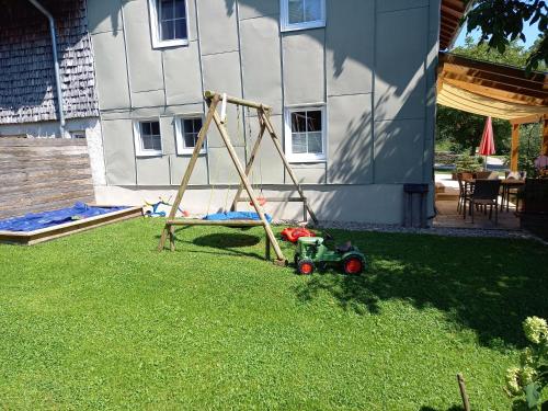 a toy tractor in the grass in a yard at Landhof Ella - Ferienhaus vor den Toren Salzburgs in Petting