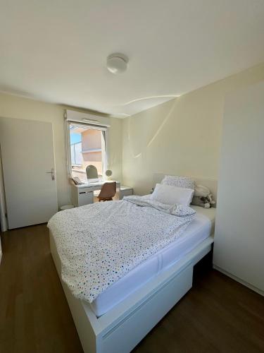 une chambre blanche avec un lit et une fenêtre dans l'établissement Maison 15 min Disney 30 min Paris, à Ferrières-en-Brie