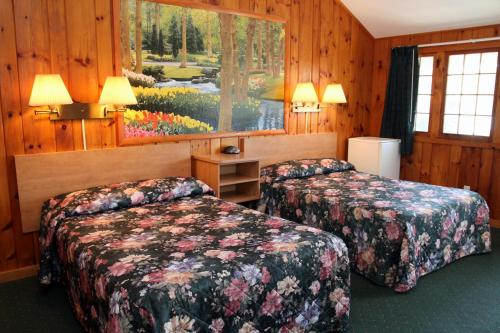 a hotel room with two beds and a window at Studio Motel of Lake George in Lake George