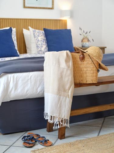 a bed with a basket and a pair of sandals at Aetheron Villa, Naousa in Naousa
