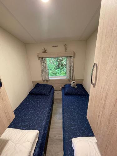 two beds in a small room with a window at Chalet JT08 in Renesse in Renesse