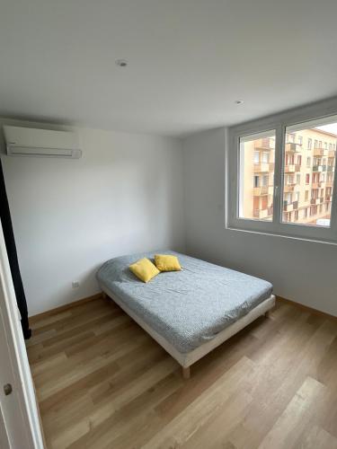 - une chambre avec un lit doté de 2 oreillers jaunes dans l'établissement Vue sur les montagnes au frais, à Romans-sur-Isère