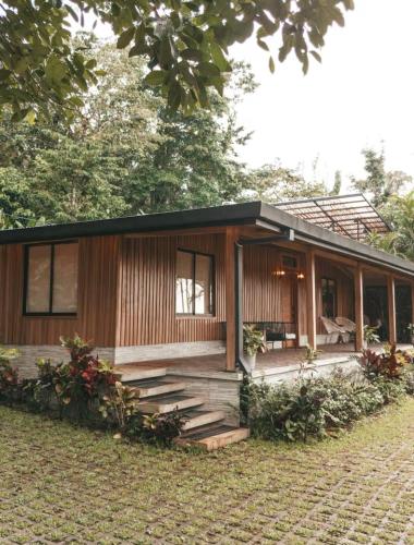 a wooden house with a porch and stairs at Arenal Nest in San Francisco
