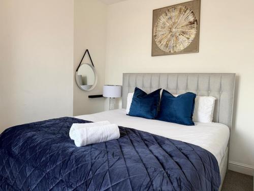 a bedroom with a large bed with blue pillows at City Centre Embankment Apartments Superb Location in Cardiff