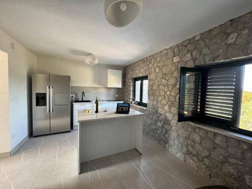 a kitchen with a stone wall and a refrigerator at Sreser Domus Nostrae - Peljesac 2 Only adults in Sreser