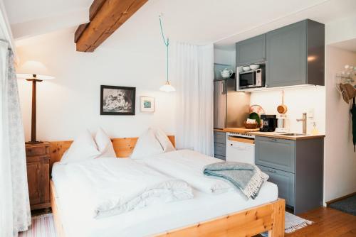 a bedroom with a large bed and a kitchen at Strandcafé Hideaways Altaussee in Altaussee