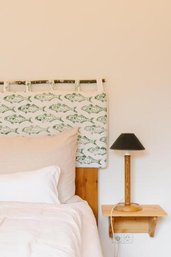 a bedroom with a bed and a table with a lamp at Strandcafé Hideaways Altaussee in Altaussee