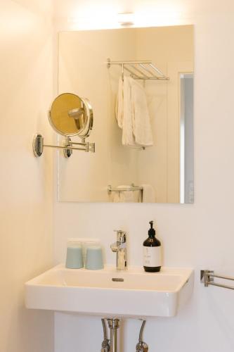 a bathroom with a sink and a mirror at Strandcafé Hideaways Altaussee in Altaussee