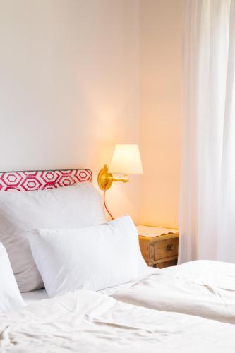 a bedroom with two white beds and a lamp at Strandcafé Hideaways Altaussee in Altaussee