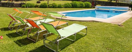 a group of lawn chairs sitting next to a swimming pool at House Sopo in Vila Nova de Cerveira
