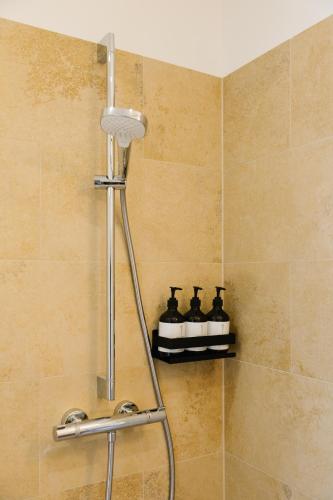 a shower with two bottles on a shelf in a bathroom at Strandcafé Hideaways Altaussee in Altaussee