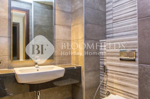 a bathroom with a sink and a mirror at Bloomfields Elegant 1BR Ajwan Soul Beach Access in Abu Dhabi
