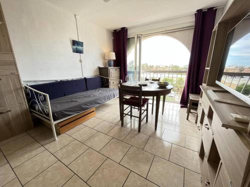 un salon avec un canapé et une table dans l'établissement Studio cabine CAP D'AGDE NATURISME CN010-576, au Cap d'Agde