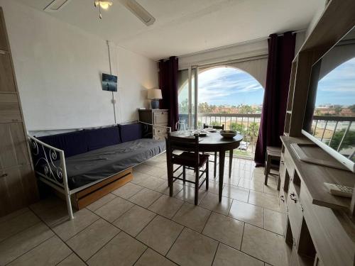 Cette chambre comprend un lit, une table et une salle à manger. dans l'établissement Studio cabine CAP D'AGDE NATURISME CN010-576, au Cap d'Agde