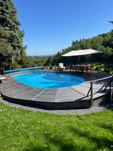 a swimming pool with a deck and a picnic table at Naturalna Cisza in Michałkowa