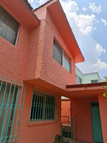a red house with a gate in front of it at Confortables habitaciones en zona residencial de Vista Bella, Morelia Michoacan in Morelia