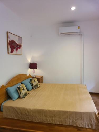a bedroom with a large bed with blue pillows at Cozy house by the sea in Ko Phangan