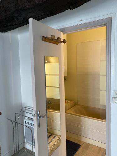 - une porte ouverte donnant sur une salle de bains pourvue d'une baignoire dans l'établissement Studio de la mer, à Saint-Malo