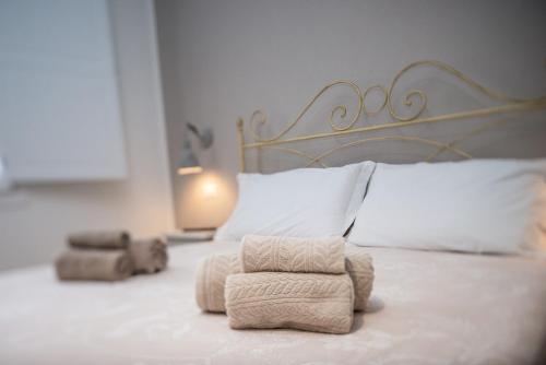 a bedroom with a bed with a headboard and two towels at Casa Midò in Muravera