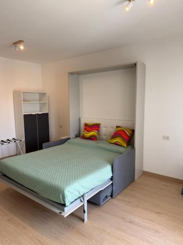 Un dormitorio con una cama grande con almohadas de colores. en MarteNik Apartment, vicino San Raffaele e Milano, en Vimodrone