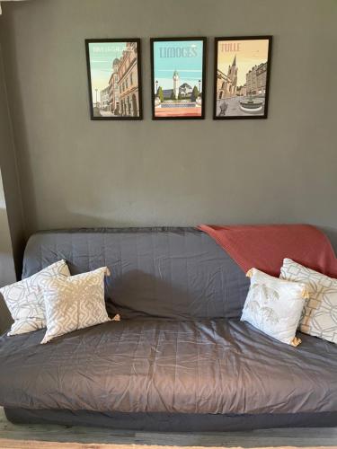a gray couch with four pictures on the wall at Pandrignes, appartement F2 in Pandrignes
