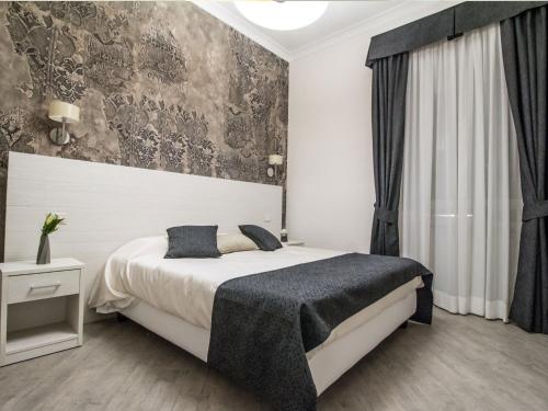 a bedroom with a large bed and a wall at Velvet Suite in Rome