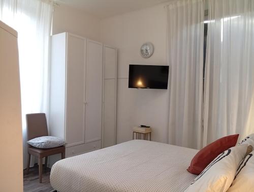 Un dormitorio con una cama y un televisor en la pared. en Covenate House, en Como
