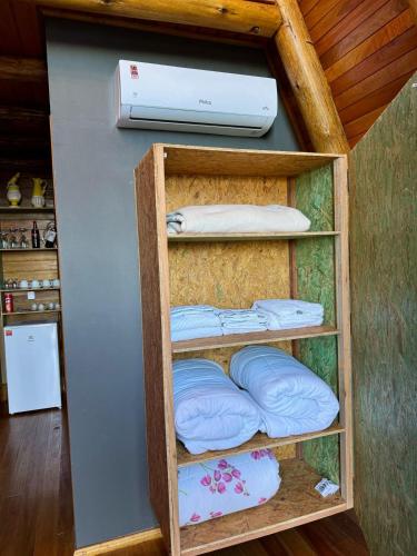 a room with a shelf with pillows and a printer at Chalé amanhecer Serra do Rio do Rastro in Louro Müller