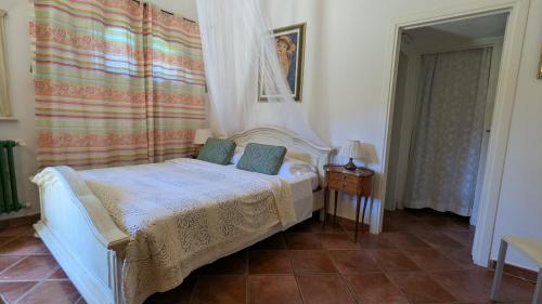 a bedroom with a white bed with a canopy at Podere Isabella in San Vincenzo