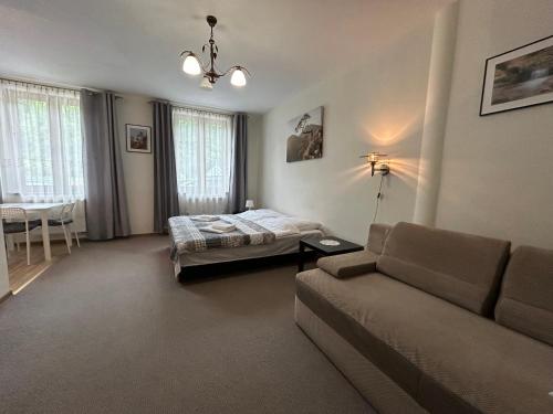 a living room with a couch and a bed at Pokoje Gościnne Młyn Bosaka in Ojców