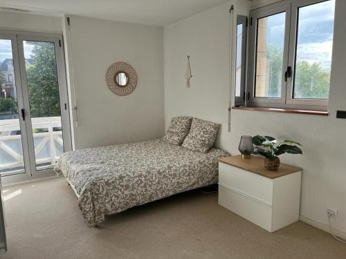 une chambre avec un lit, une table et des fenêtres dans l'établissement Joli studio - 1ere ligne- Front de mer Royan, à Royan