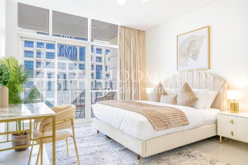 Un dormitorio con una cama y un escritorio y una ventana. en Bloomfields Grandeur 1BR In Lamar Raha, en Abu Dabi