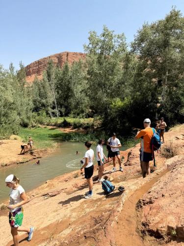 a group of people standing on the side of a river at Alliance tradition in Boumalne