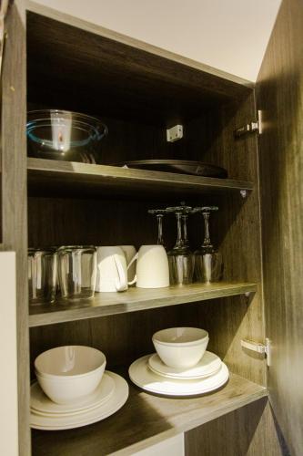 a cupboard with plates and bowls in it at Accra Luxury Apartments @ The Lennox in Accra