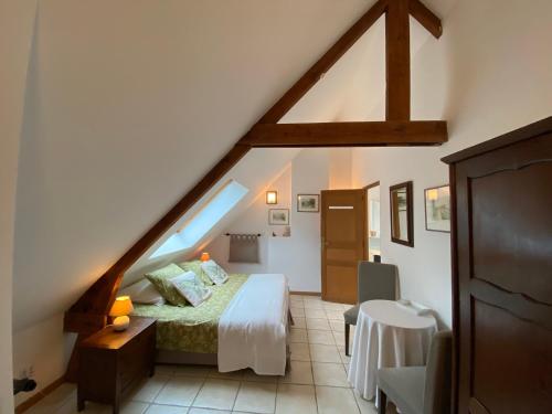 - une chambre mansardée avec un lit et une table dans l'établissement Villa Boréas, à Wissant