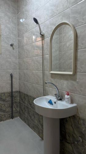 a bathroom with a sink and a mirror and a shower at hajer221 in Al Hofuf