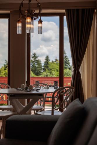 a dining room with a table and chairs and a window at Palic Memories by Vermes - Lake View in Palić
