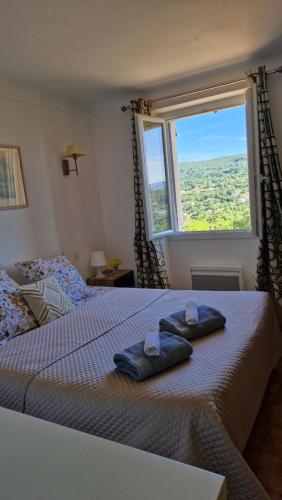 une chambre avec un lit avec deux serviettes dessus dans l'établissement Le Jardin des Oliviers, à Apt