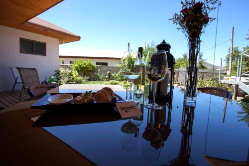 een tafel met een bord eten en een glas wijn bij Umawtu Bed and Wine in Casablanca