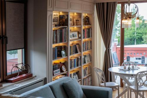 a book shelf filled with books next to a table at Palic Memories by Vermes - Lake View in Palić
