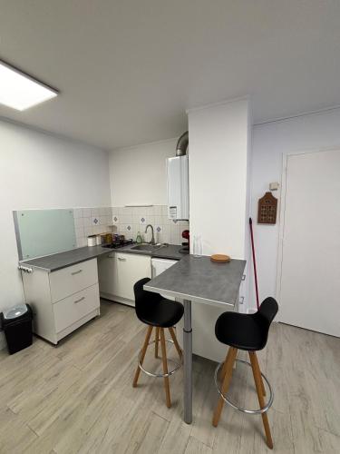 une petite cuisine avec une table et deux chaises dans l'établissement Appartement cosy à Cherbourg!, à Cherbourg en Cotentin