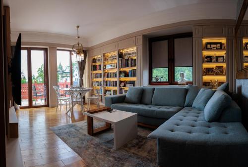 a living room with a blue couch and a table at Palic Memories by Vermes - Lake View in Palić