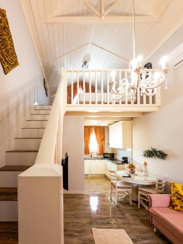 a living room with a staircase and a dining room at Nafsika Suites in Nea Moudania