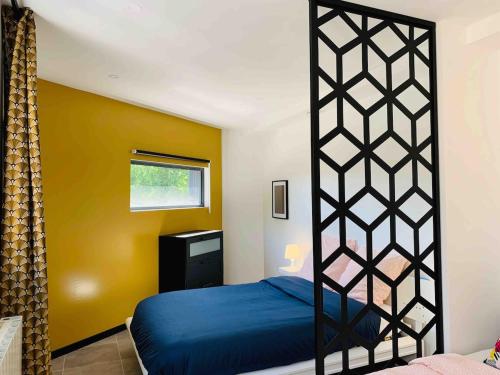 - une chambre avec un lit bleu et un mur jaune dans l'établissement Apartment rooftop stadium of France metro line 13, à Saint-Denis